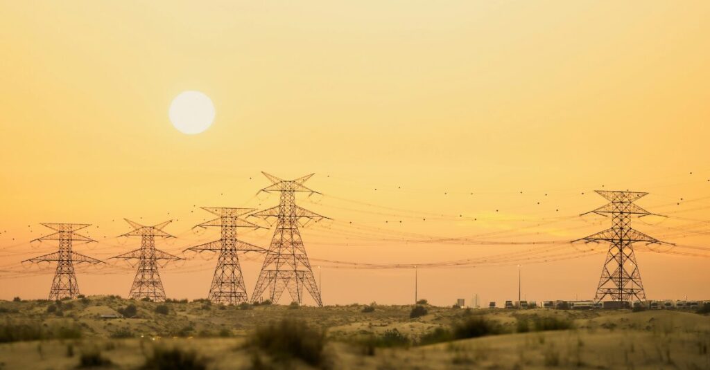 Power lines in a field during a sunset